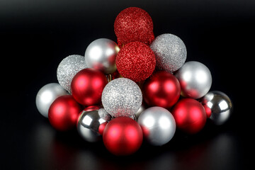 Composition from a red and silver shiny and matte christmas balls close up view on black background