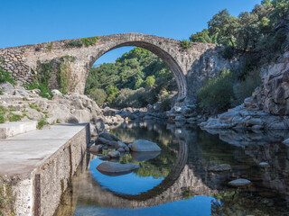 Fototapeta na wymiar Stone bridge over the canyon of the Alardos river (Garganta de Alardos). Madrigal de la Vera, Caceres, Extremadura, Spain