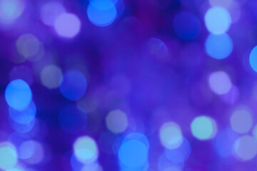 Blurred blue, dark blue, purple, violet garland lights. Abstract background