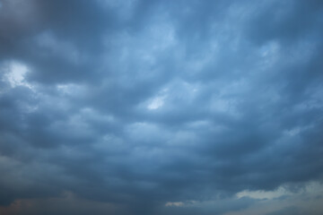 Thick clouds cover all over the sky, the clouds look blue along with the sky