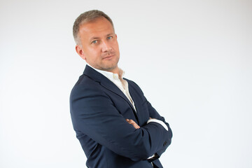 Handsome young business man smiling with arms crossed on white background