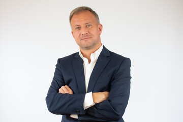Handsome young business man smiling with arms crossed on white background