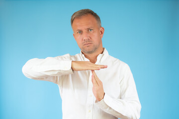 Young man giving showing time out hands gesture isolated on blue background