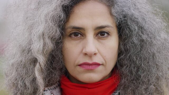 Portrait of youthful older looking woman looking to camera with a blank expression on her face
