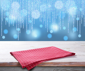 Red napkin on wooden table and Christmas background.