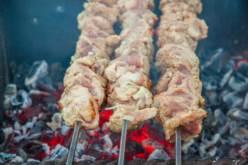 Three skewers with shish kebab. The concept of cooking meat on the coals