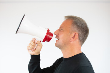 Young man talking in the megaphone on white background
