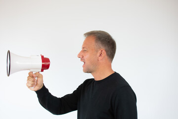 Young man screaming in the megaphone on white background