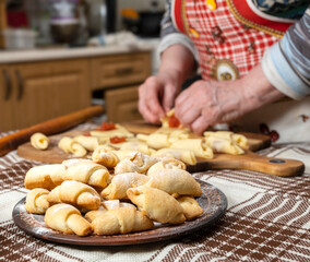 Woman preparing homemade rolls with jam  at home