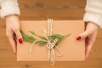 Female hands hold waste-free gift boxes and recyclable eco-friendly packaging for various holidays, Christmas, Valentine's Day, on a wooden background. Zero waste concept, environmental protection