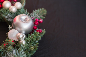 Christmas wreath for decorating doors or a table made of natural green spruce with glass New Year's red balls and silver decorations.  Home decor for winter holiday.