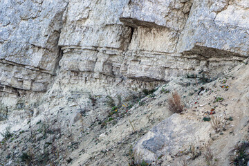 sandy-gypsum cut of the earth in quarry for the extraction of gypsum. Mountain textures of different soil layers with deposits of sand, clay, gypsum, quartz and gypsum ore, after erosion.