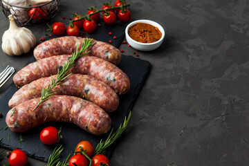 raw sausages with ingredients on a cutting board on a stone background - 396757147
