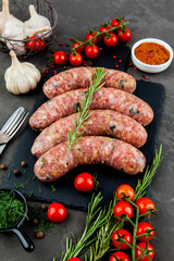 Grilled sausages with rosemary herbs and tomatoes on a black background. Top view - 396757330