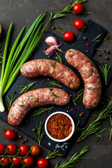 Bavarian or Munich hot sausages with seasonings and sauces on a stone board. - 396757561
