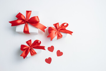 Gift boxes with red ribbon and hearts on white background. Valentines day banner with free space. Top view, flat lay.