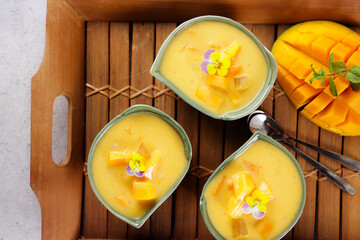 Mango sago. Sweet sago cream with mango, coconut milk and mango juice garnish with edible flower.