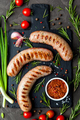 Grilled sausages with rosemary herbs and tomatoes on a black background. Top view - 396757777