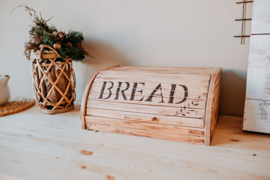 Christmas decorations. Bascet with fir branches and breadbox on the wooden table. Festive table decorations.