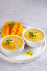 Mango sago. Sweet sago cream with mango, coconut milk and mango juice garnish with edible flower.