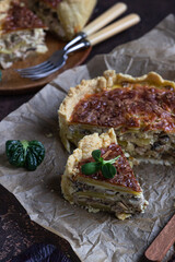 Homemade chicken, mushroom and potato open pie or quiche, dark rustic concrete background. French cuisine.