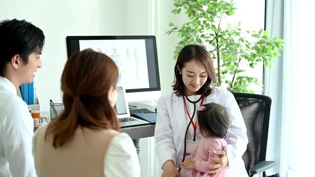 赤ちゃんを抱っこして聴診器を当てる女性医師