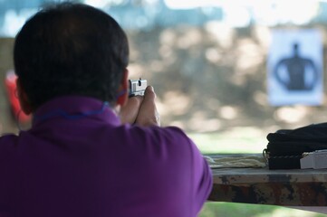 law enforcement aim pistol by two hand in academy shooting range in flare and vintage color, focus...