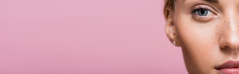 cropped view of beautiful woman with freckles isolated on pink, banner