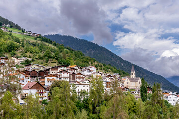 Obraz premium Panoramic view of the town of Stelvio, South Tyrol, Italy, with a dramatic sky in the background