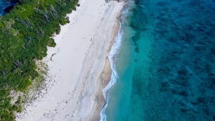 平行線状の模様が美しいビーチを見下ろすドローン空撮写真