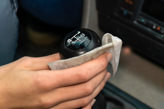 Woman's hand wipes the lever, the car selector with a napkin close-up. Dirty napkin
