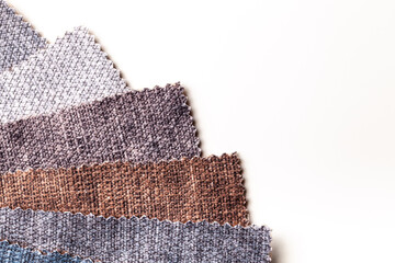 Swatch of velvet textile brown and gray colors on white table, background.