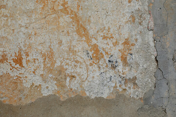 Damaged stone wall with different structure and colors, blank facade with grey cement, space for text on the background