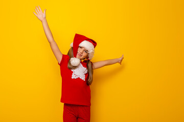 Fototapeta na wymiar Little girl wearing Santa hat holding hands up