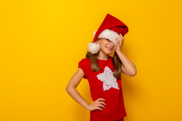 Child wearing Santa hat holding head in hands