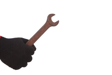 The hand of a man in a working glove holds an old rusty wrench. Isolated on white background