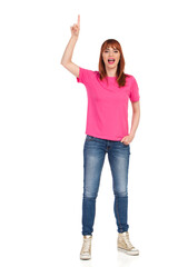 Fototapeta premium Casual Young Woman Is Standing, Pointing Up And Talking