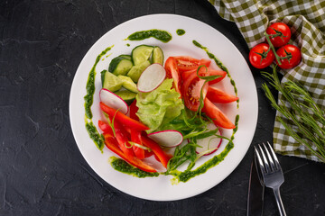 fresh sliced vegetables (peppers, cucumbers, tomatoes, lettuce and radishes) on a white plate for the restaurant menu.