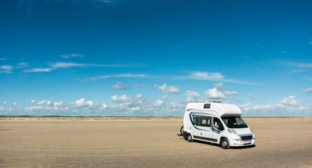 Camping Car RV standing on empty sand beach panorama on sunny day. Romo Bilstrand, Lakolk Strand,...