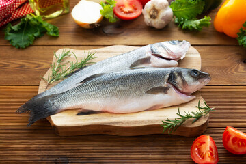 Seabass fish isolated on wooden background, top view.