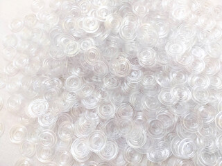 Lots of white transparent buttons for clothes. Background on the theme of light industry. Plastic round buttons
