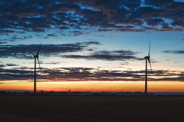 Obraz premium Two large windmills on the shore of the lake Markermeer during sunrise