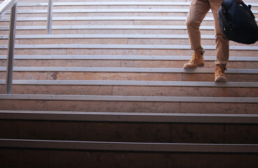 Unrecognizable man running into the underground with a backpack in his hands. Panoramic photography concept 2020. Everyday lifestyle.