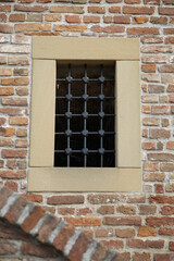 Barred window in a vintage red brick wall, wallpaper.