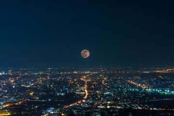 the Last Penumbral Lunar Eclipse in 2020 over Chiang mai city at night , multiple exposure