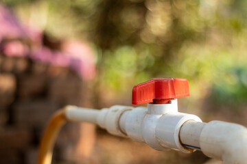 Red switch on white plastic water pipeline