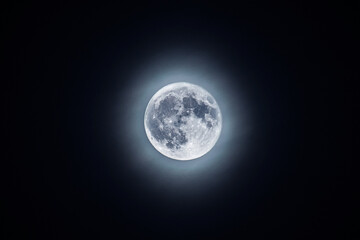 Full blue moon with halo of light. Beautiful astronomical phenomenon.