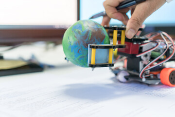 Student learning STEM Education for Learn coding programming with Control robot to pick up model globe by robotics electronics in school, program in technology for innovation futuristic