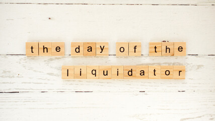 the day of the liquidator.words from wooden cubes with letters photo