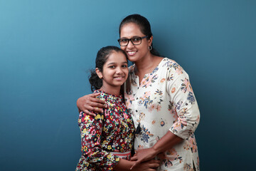 Naklejka premium Smiling mother and daughter of Indian ethnicity hugging together